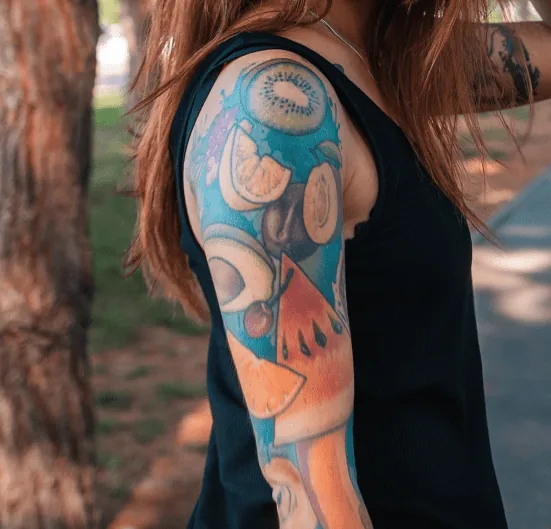 Brightly coloured full arm sleeve tattoo in blues, oranges and greens