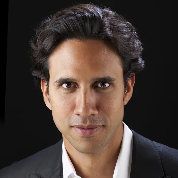 Professional headshot of a man in a suit and open-collar shirt