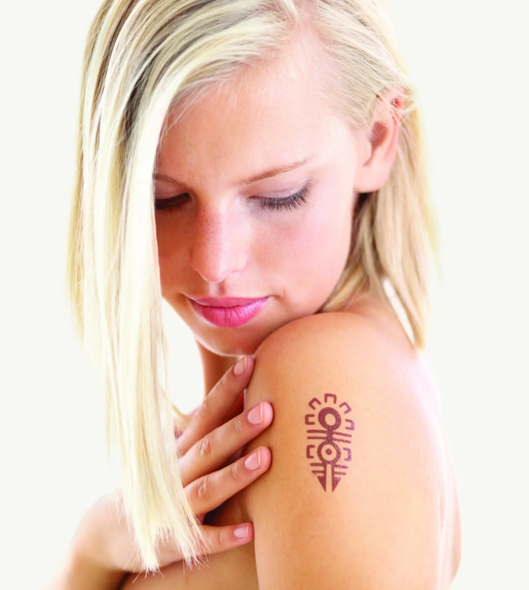 Small decorative shoulder tattoo on a woman's upper arm